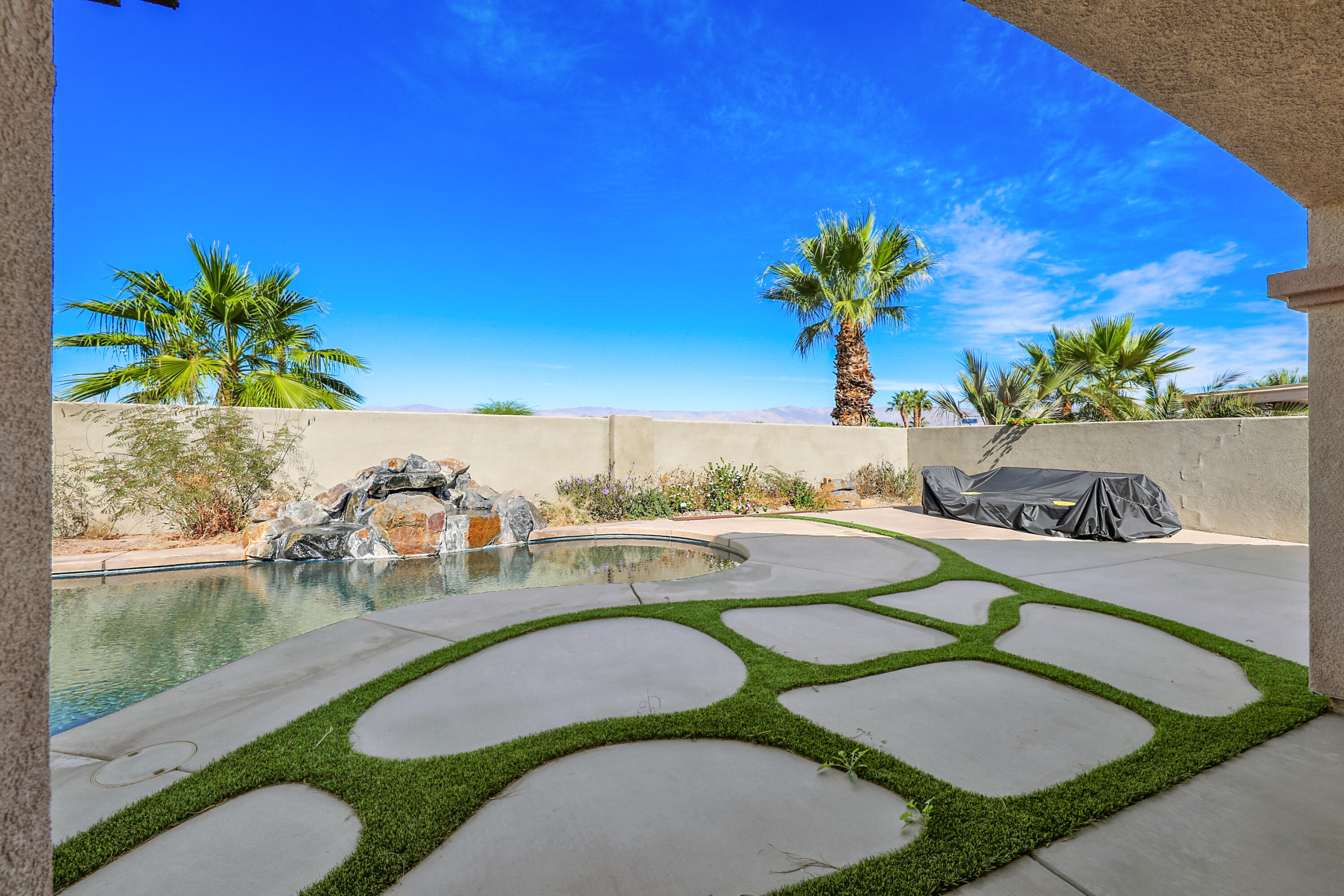 79948 Bethpage Avenue Indio, CA 92201 - Photo 21 of 30 a view of a swimming pool with a yard