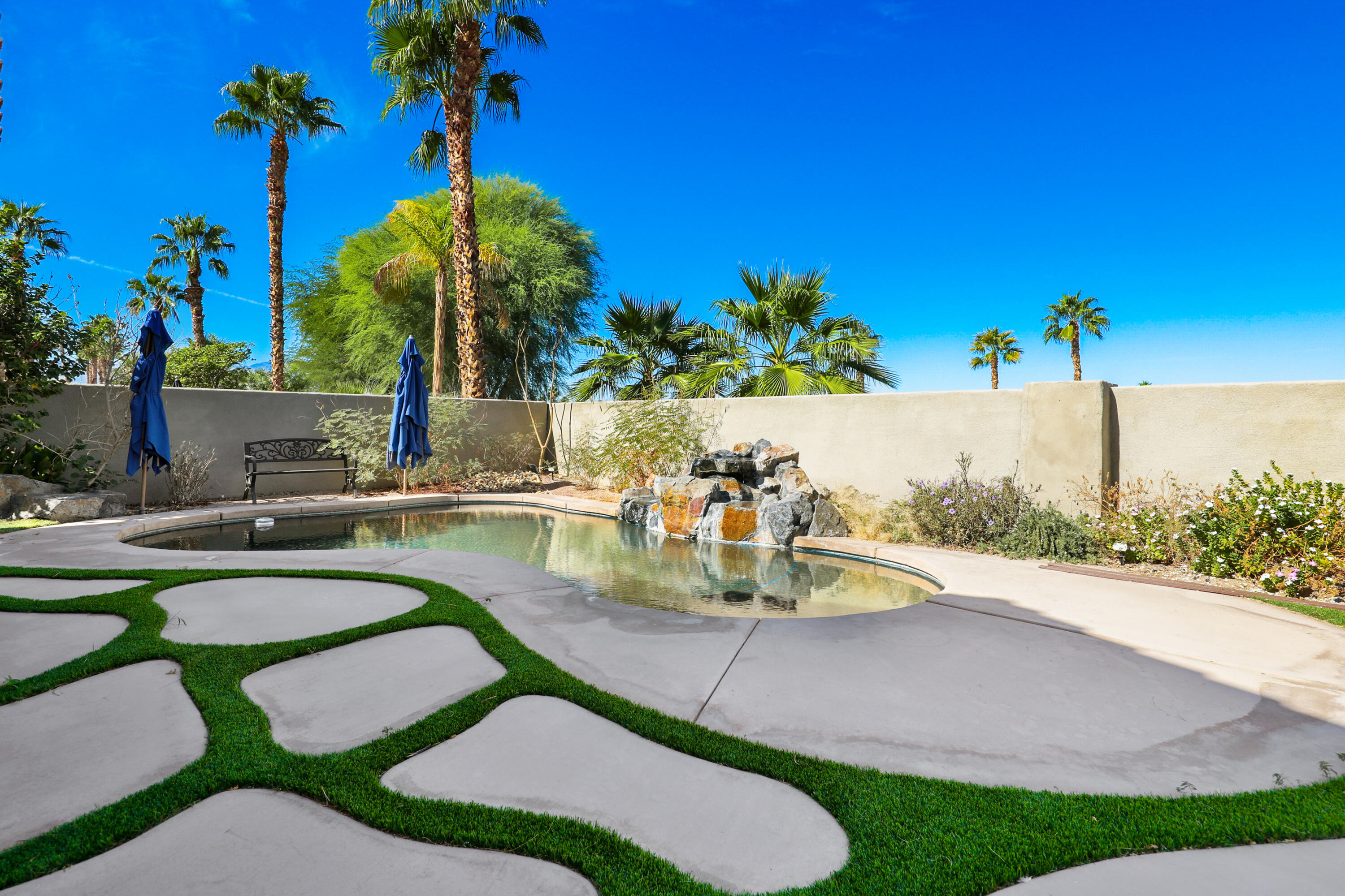 79948 Bethpage Avenue Indio, CA 92201 - Photo 22 of 30 a view of a backyard with plants and swimming pool