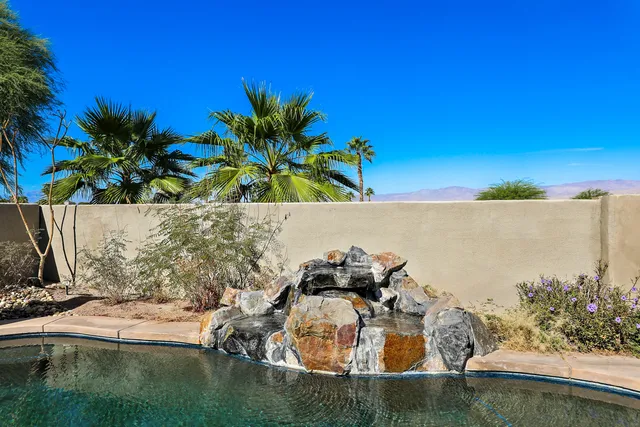 a view of small pool with lawn chairs