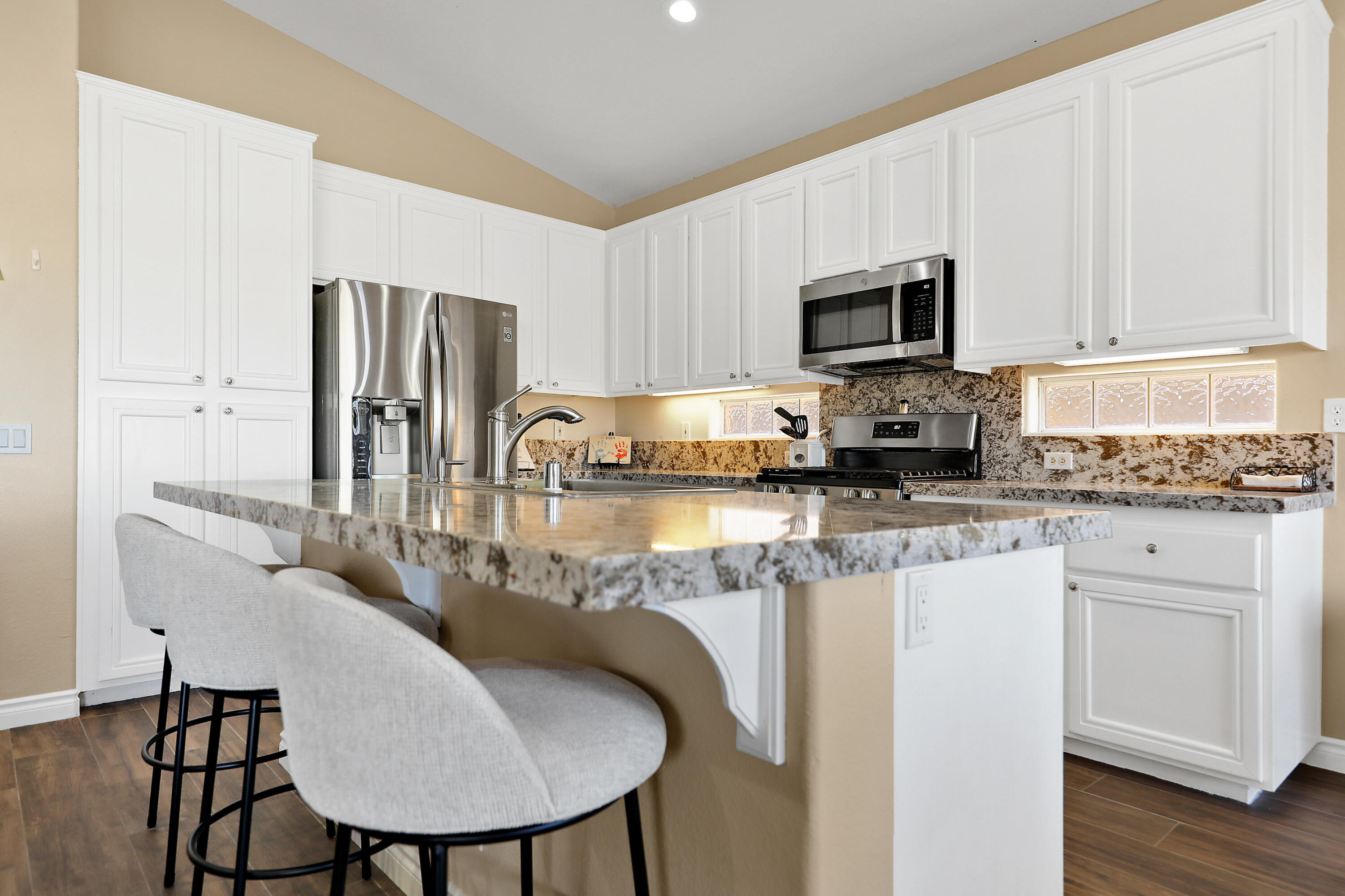 79948 Bethpage Avenue Indio, CA 92201 - Photo 9 of 30 a kitchen with stainless steel appliances granite countertop a sink a microwave refrigerator and cabinets