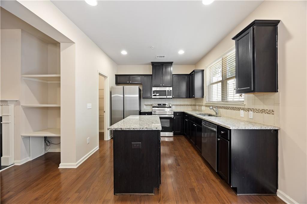 2296 Thackery Road Southwest Snellville, GA 30078 - Photo 9 of 26 a kitchen with stainless steel appliances granite countertop a sink stove and refrigerator