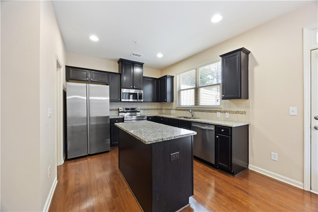 2296 Thackery Road Southwest Snellville, GA 30078 - Photo 10 of 26 a kitchen with stainless steel appliances granite countertop a sink stove and refrigerator
