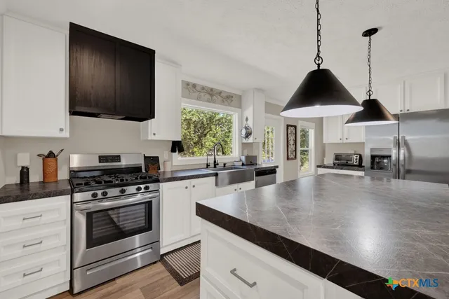 a bedroom with a bed and a lamp on dresser