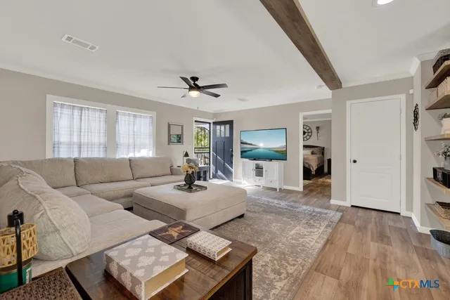 a bedroom with a bed and a flat tv screen on the dresser