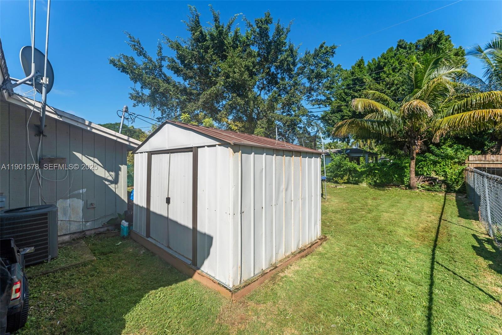 313 Northwest 12th Street Homestead, FL 33030 - Photo 14 of 16 a backyard of a house with plants and wooden fence