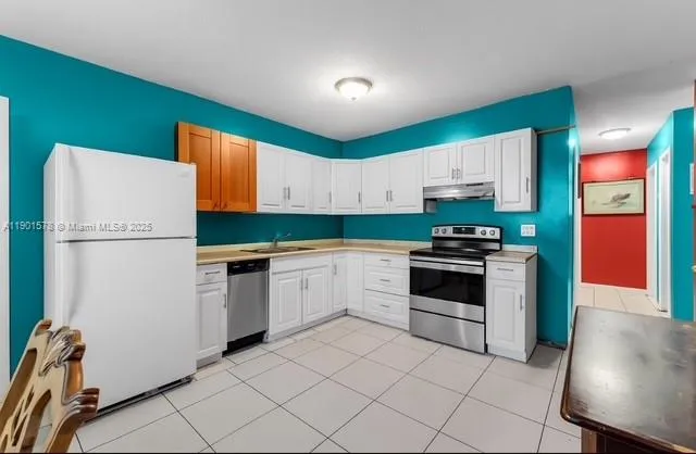 a kitchen with granite countertop a stove top oven microwave and cabinets