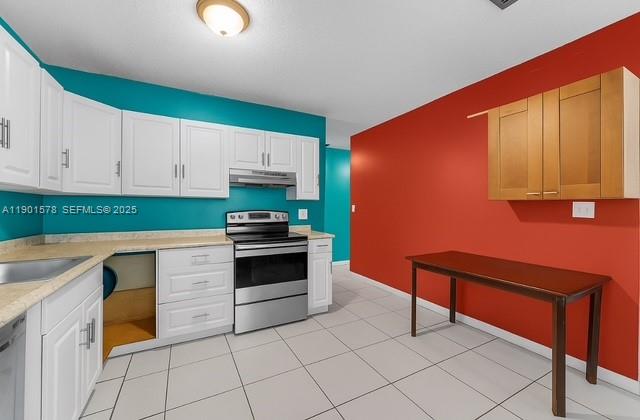 313 Northwest 12th Street Homestead, FL 33030 - Photo 7 of 16 a kitchen with granite countertop a stove top oven microwave and cabinets
