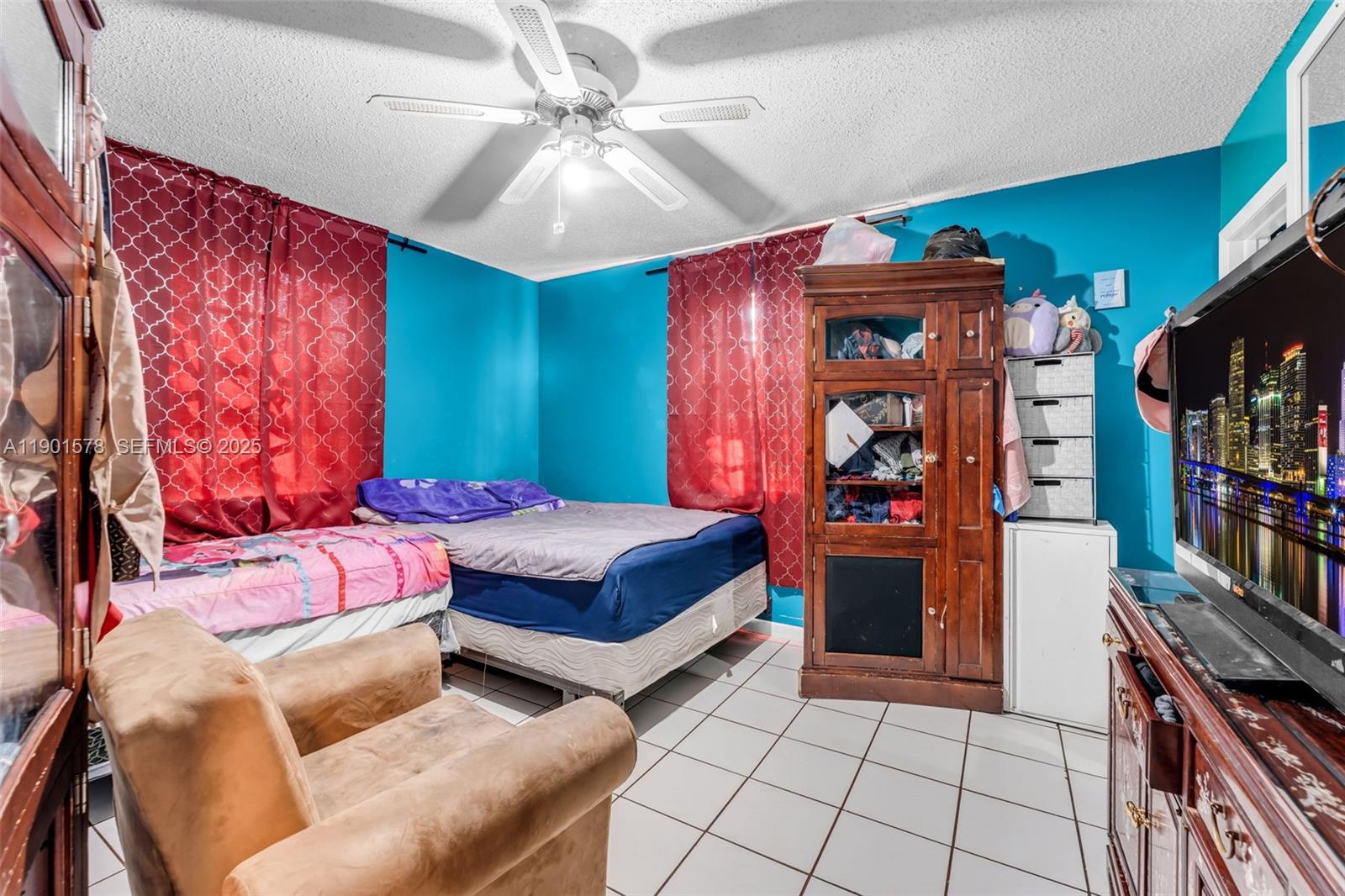 313 Northwest 12th Street Homestead, FL 33030 - Photo 9 of 16 a bedroom with a bed and a chandelier