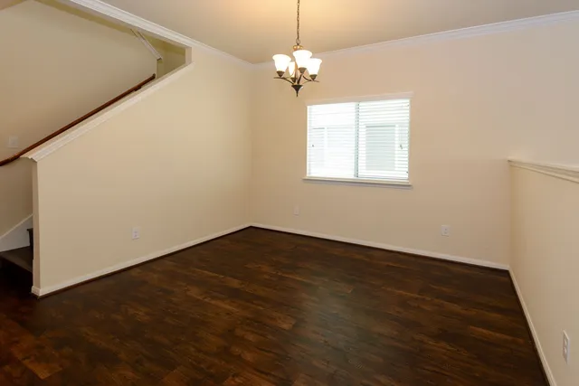 a view of a room with wooden floor chandelier and window