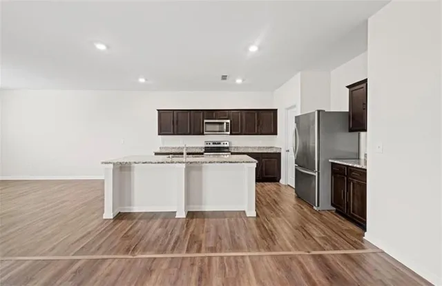 a kitchen with a refrigerator and white cabinets
