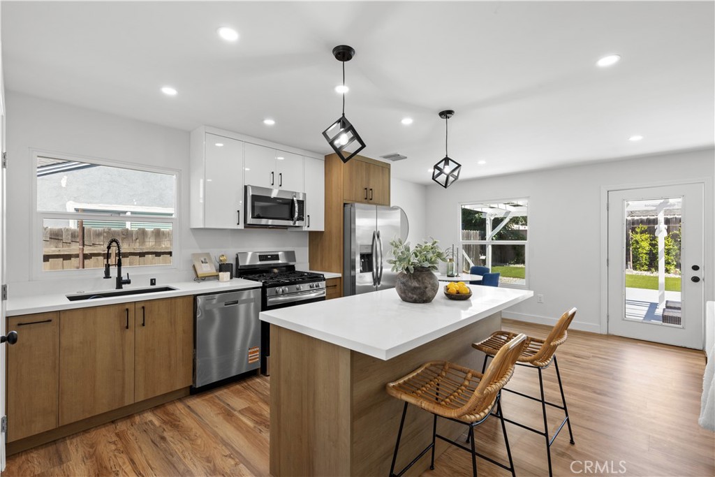 17801 Lanark Street Reseda, CA 91335 - Photo 2 of 17 a kitchen with a dining table chairs stainless steel appliances and cabinets