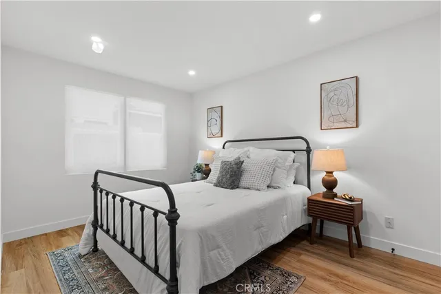 a bedroom with a bed and wooden floor