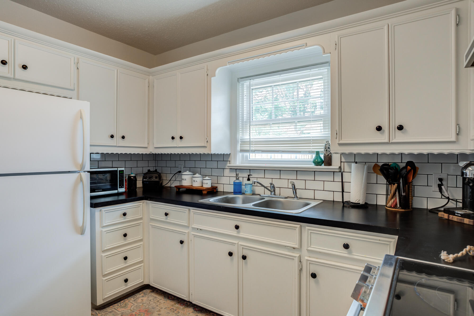 2826 33rd Street Lubbock, TX 79410 - Photo 20 of 33 a kitchen with granite countertop white cabinets white appliances and a sink