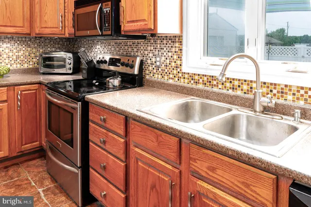 a kitchen with granite countertop a sink and a stove