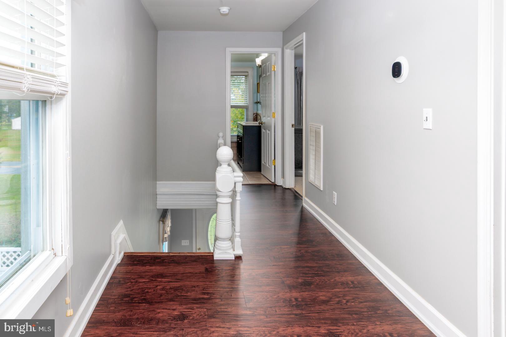4904 Ravenwood Road Vienna, MD 21869 - Photo 22 of 42 a view of a hallway with wooden floor and a living room