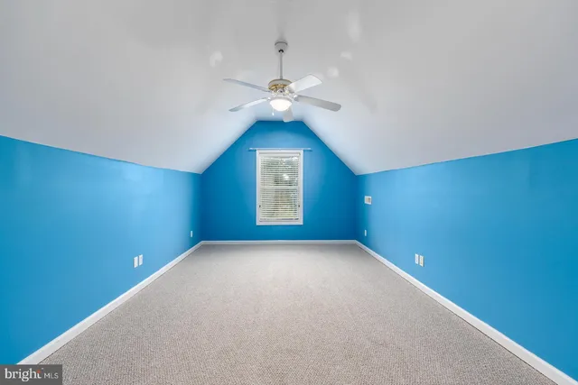 an empty room with a window and a ceiling fan