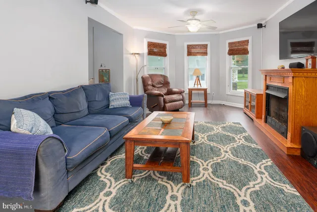 a living room with furniture a flat screen tv and a fireplace
