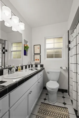 a bathroom with a sink toilet a mirror and a shower