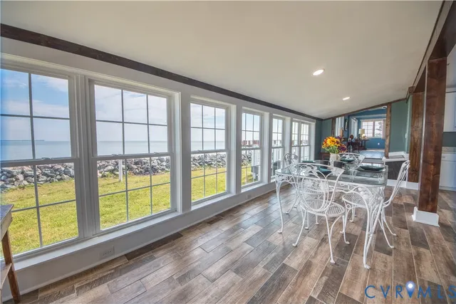 a view of a dining room with furniture water view and wooden floor