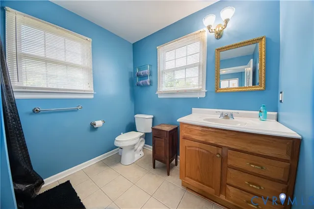 a bathroom with a sink a toilet and a window