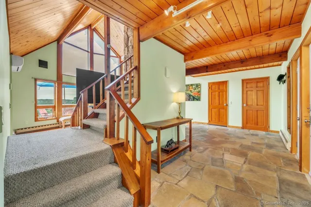 a living room with furniture floor to ceiling windows and a flat screen tv
