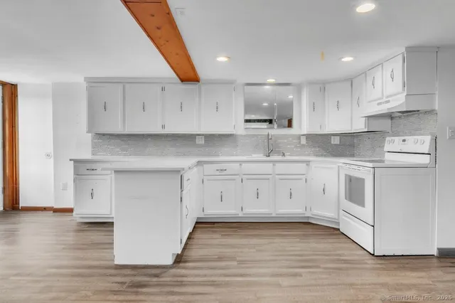 a view of a kitchen with wooden floor and windows