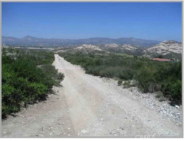 a view of a dry yard with mountains in the background