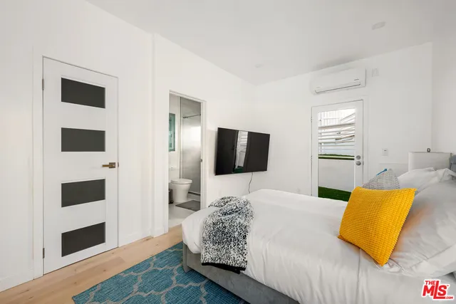 a bedroom with a bed and flat screen tv