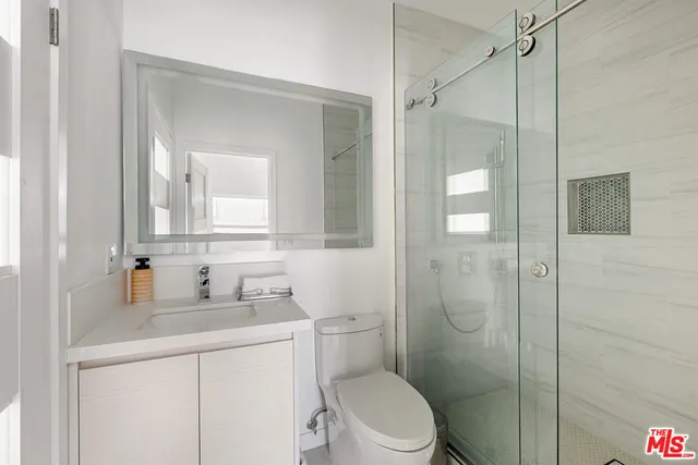 a bathroom with a sink toilet vanity and shower