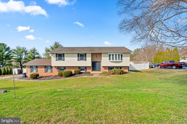 a view of a house with a big yard and large trees