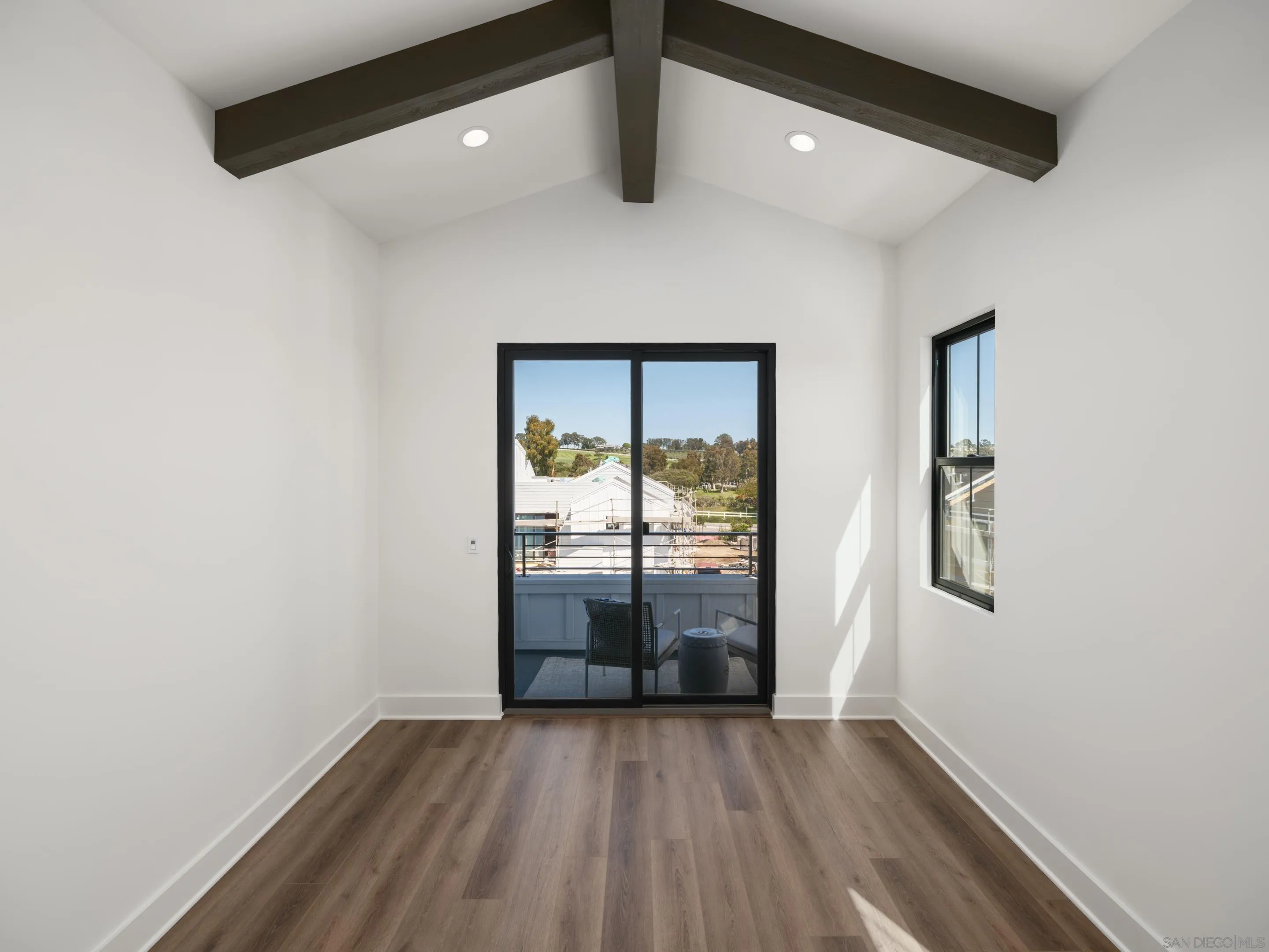 1301 Bergamo Place, Unit 101 Encinitas, CA 92024 - Photo 13 of 43 an empty room with wooden floor and windows