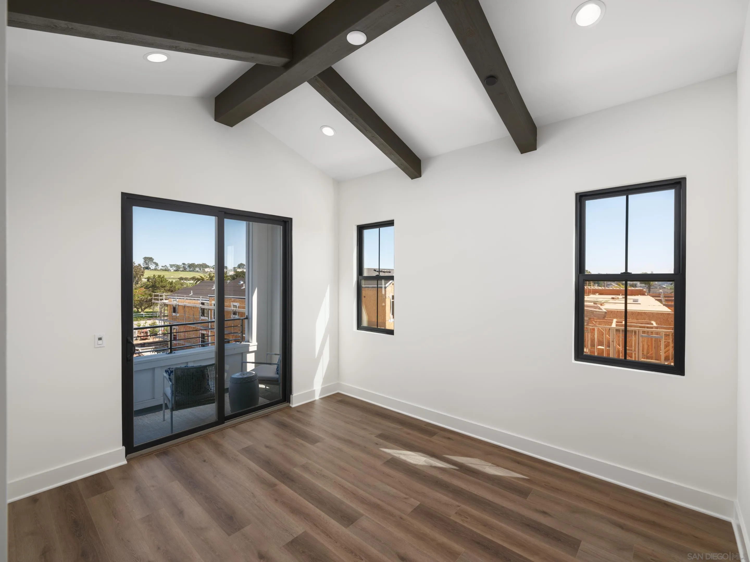 1301 Bergamo Place, Unit 101 Encinitas, CA 92024 - Photo 14 of 43 an empty room with wooden floor and windows