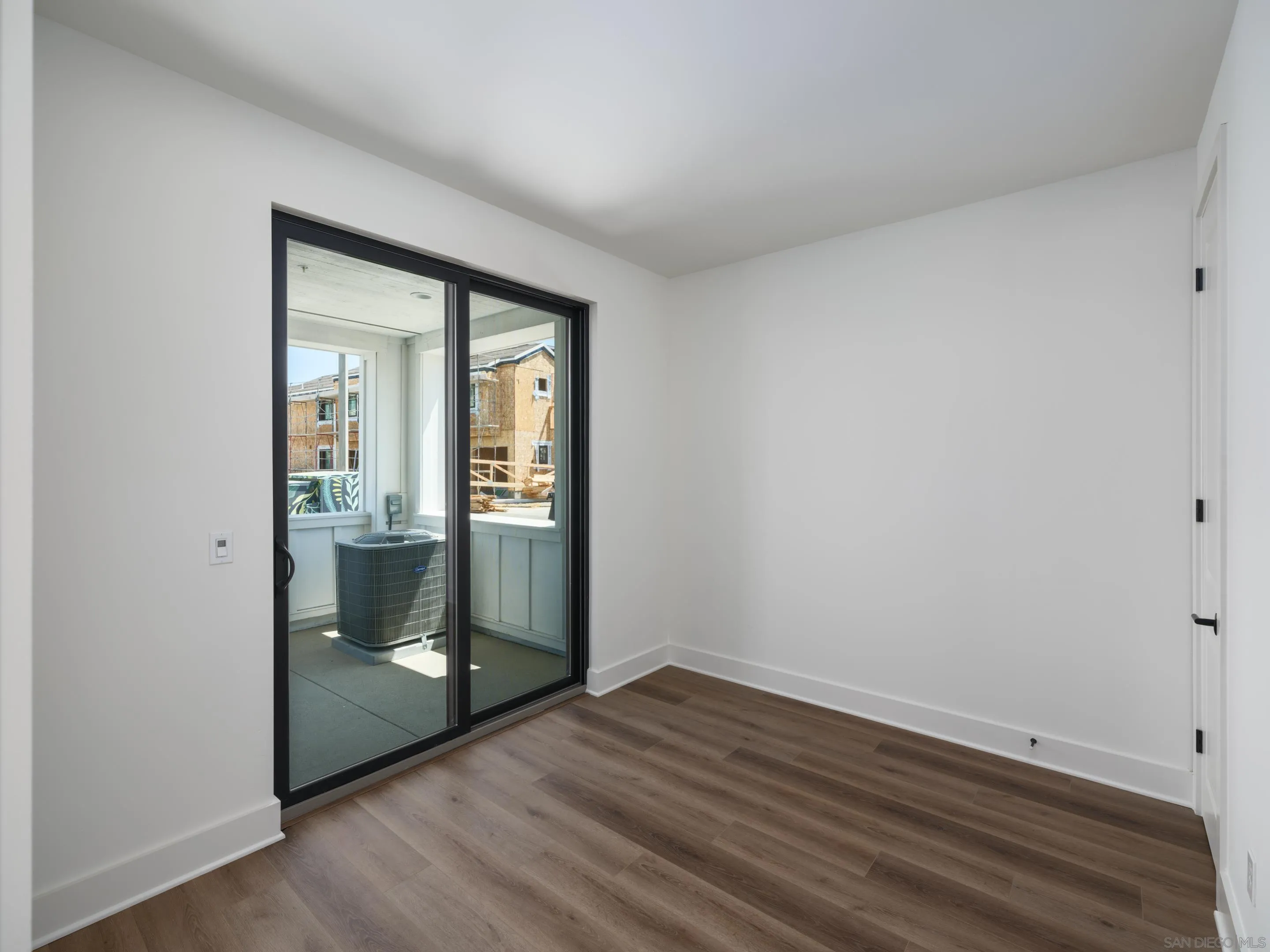 1301 Bergamo Place, Unit 101 Encinitas, CA 92024 - Photo 24 of 43 an empty room with wooden floor and door