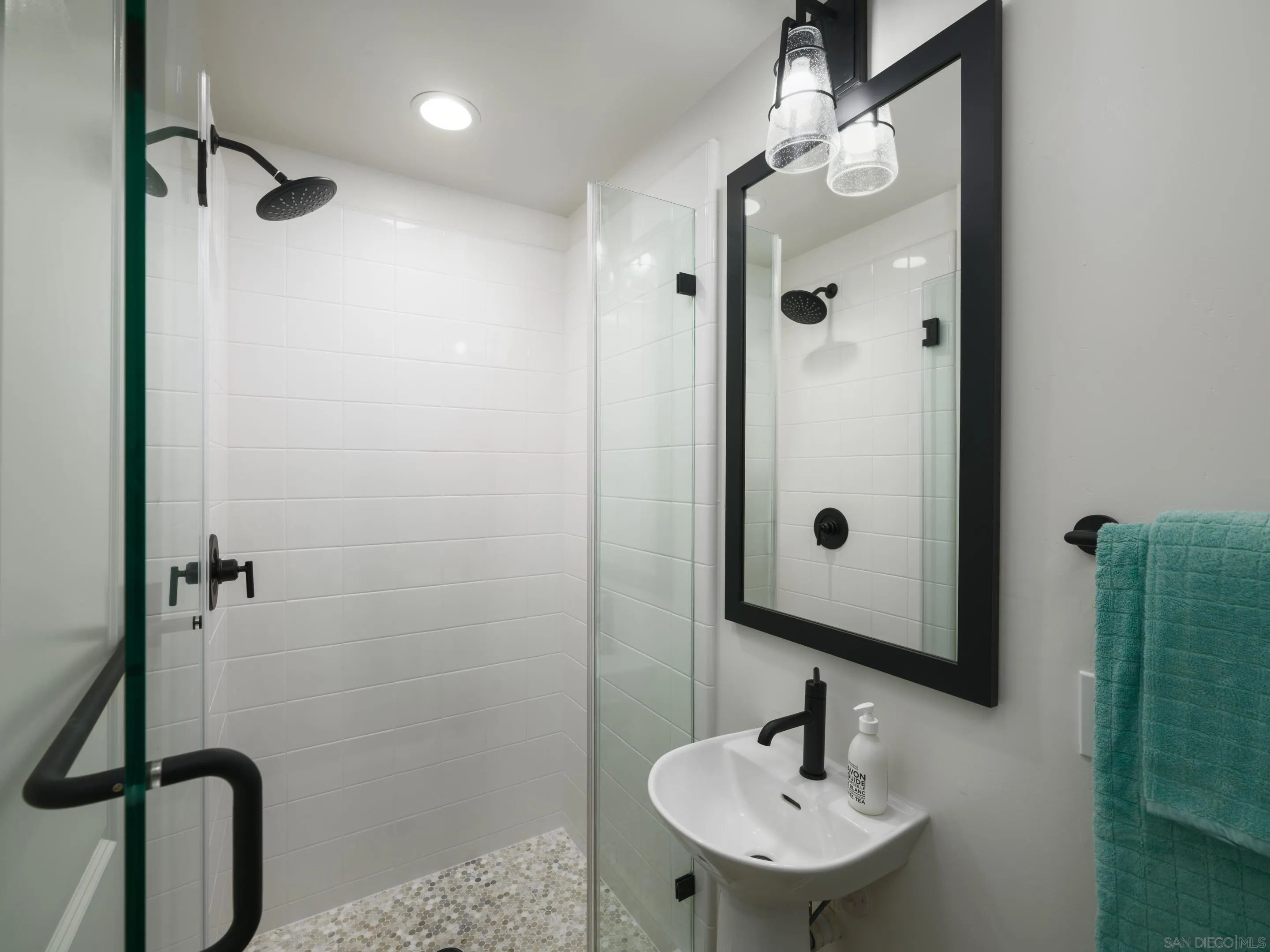 1301 Bergamo Place, Unit 101 Encinitas, CA 92024 - Photo 25 of 43 a bathroom with a sink a mirror a vanity and shower