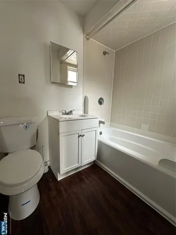 a bathroom with a granite countertop toilet sink and mirror