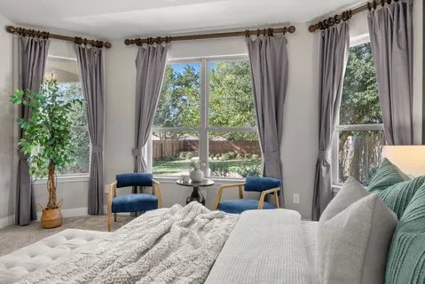 a bedroom with a bed and large windows