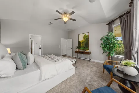 a bedroom with furniture and a large window