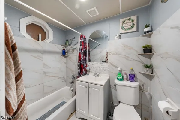 a white toilet sitting next to a bathroom sink and tub