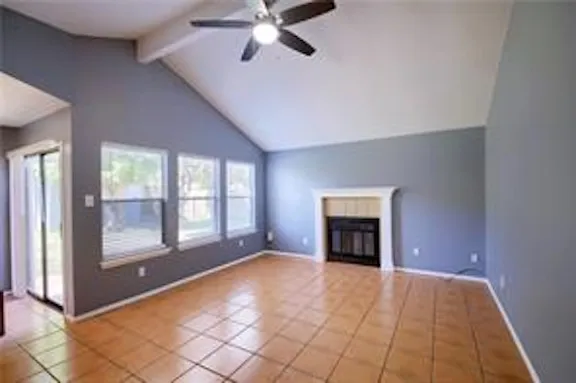a view of an empty room with a fireplace and a window