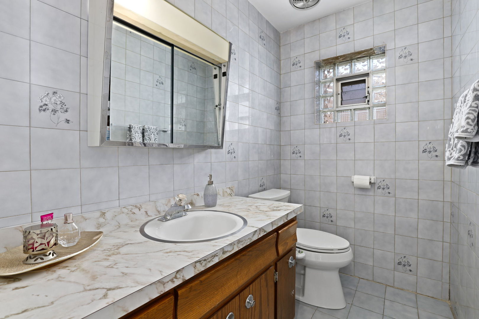 3939 Bobby Lane Schiller Park, IL 60176 - Photo 10 of 26 a bathroom with a granite countertop sink a toilet and mirror