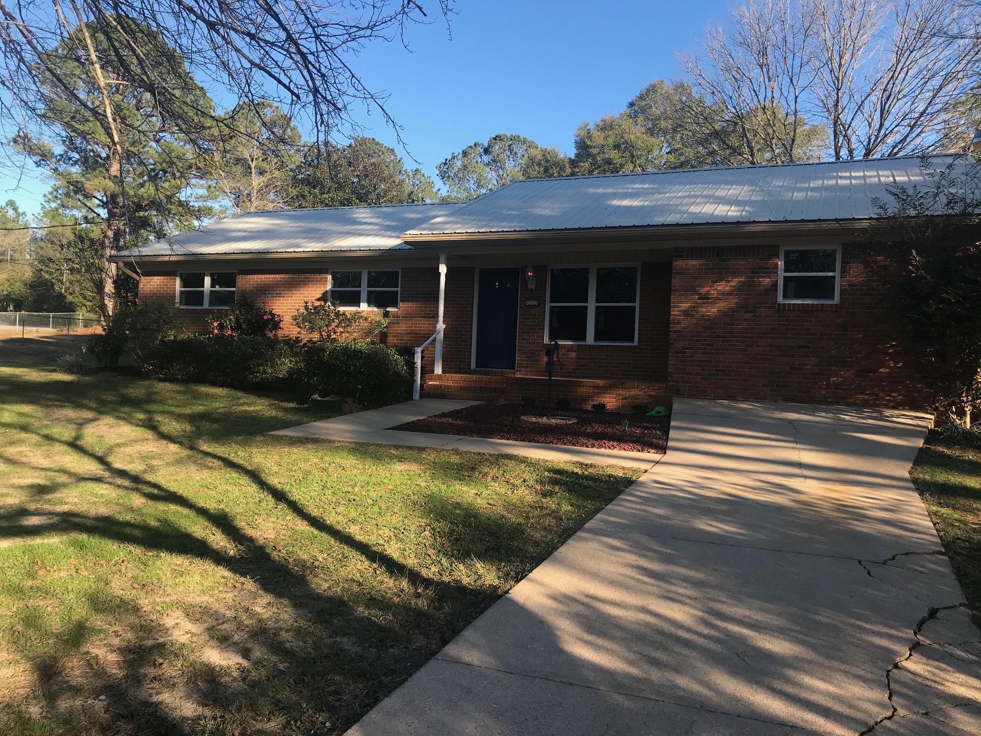 a front view of house with yard outdoor seating and barbeque oven