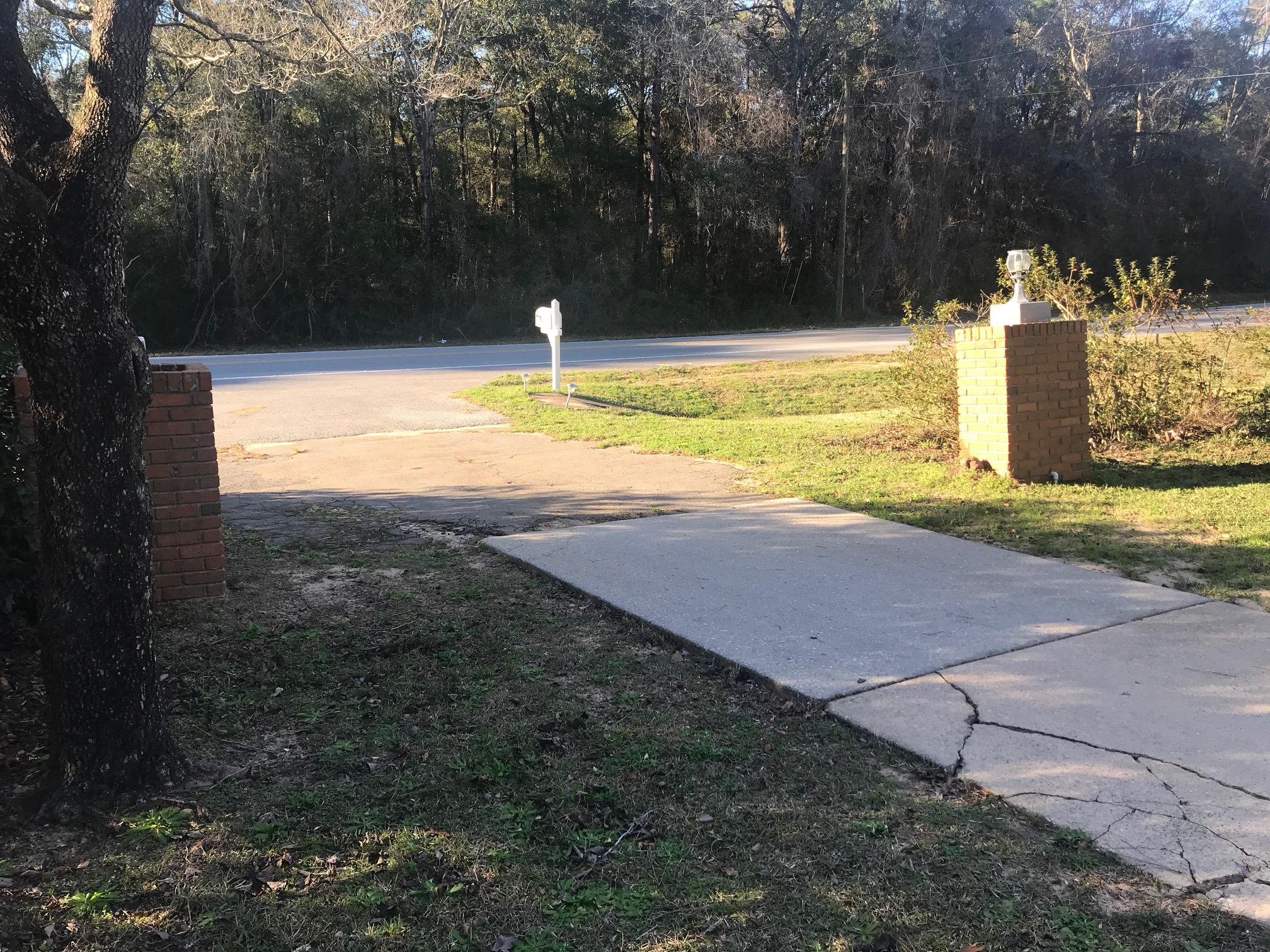 3606 Airport Road Crestview, FL 32539 - Photo 4 of 57 a view of a swimming pool with a yard and large trees