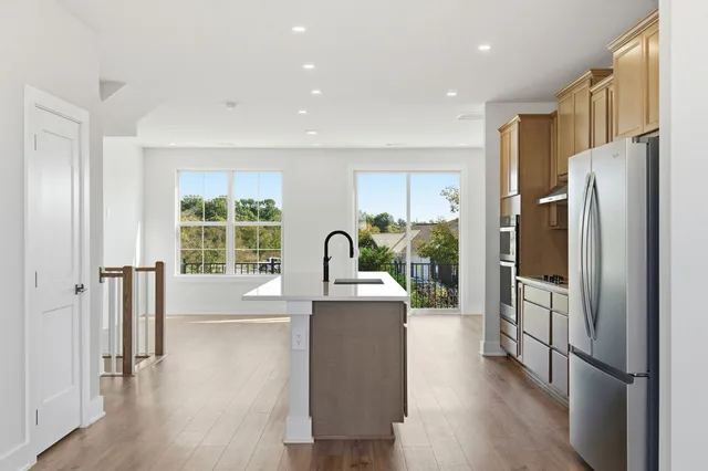 a kitchen with stainless steel appliances granite countertop a refrigerator a stove and a wooden floors