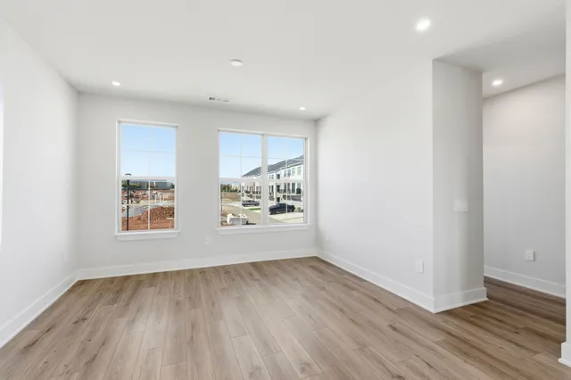 an empty room with wooden floor and window
