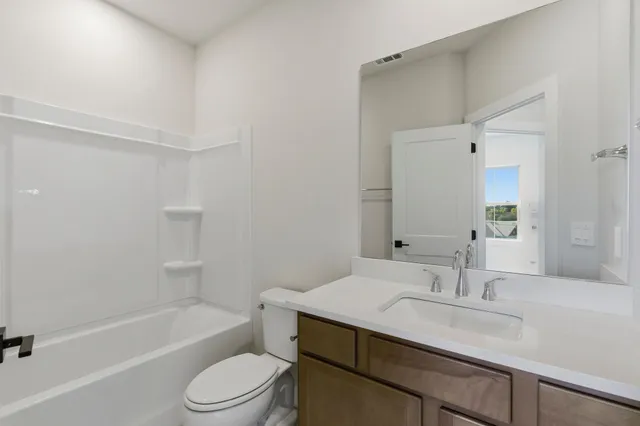a bathroom with a sink toilet vanity and shower