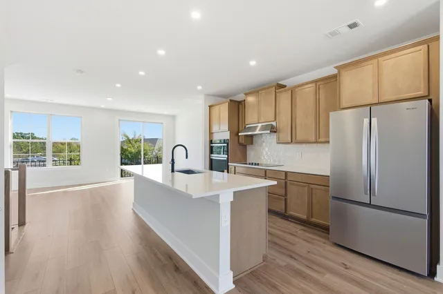 a kitchen with refrigerator cabinets and wooden floor