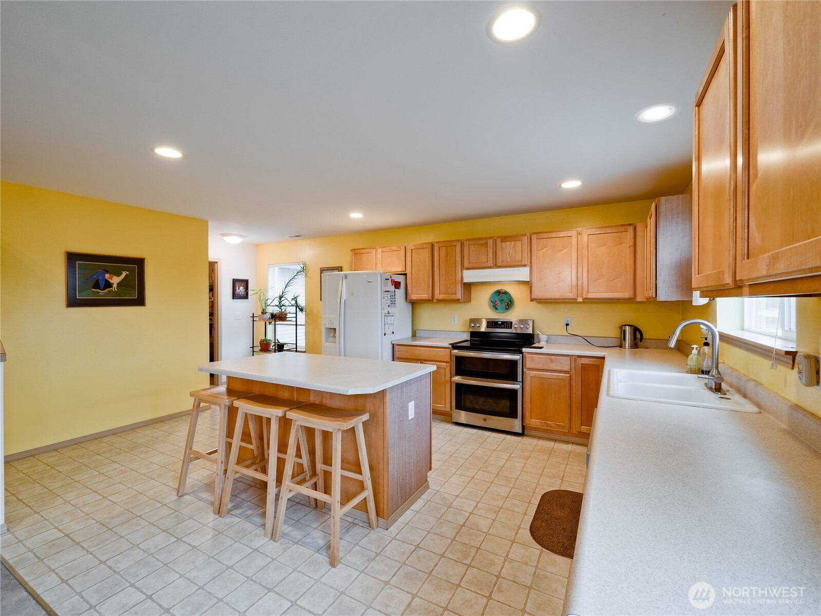 22613 132nd Place Southeast Kent, WA 98042 - Photo 9 of 36 a kitchen with stainless steel appliances granite countertop a sink a stove a dining table and chairs