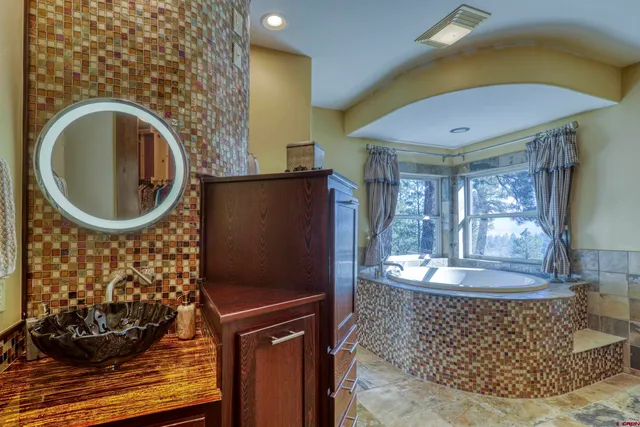 a bathroom with a granite countertop shower a sink and a mirror
