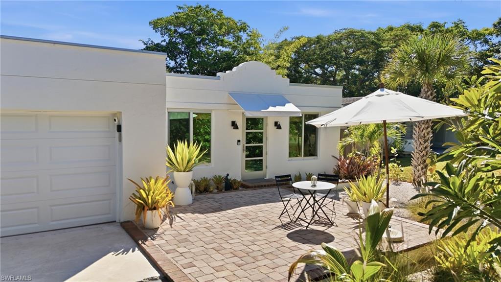 a view of a patio with table and chairs under an umbrella