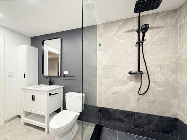 a bathroom with a granite countertop sink a toilet and a mirror